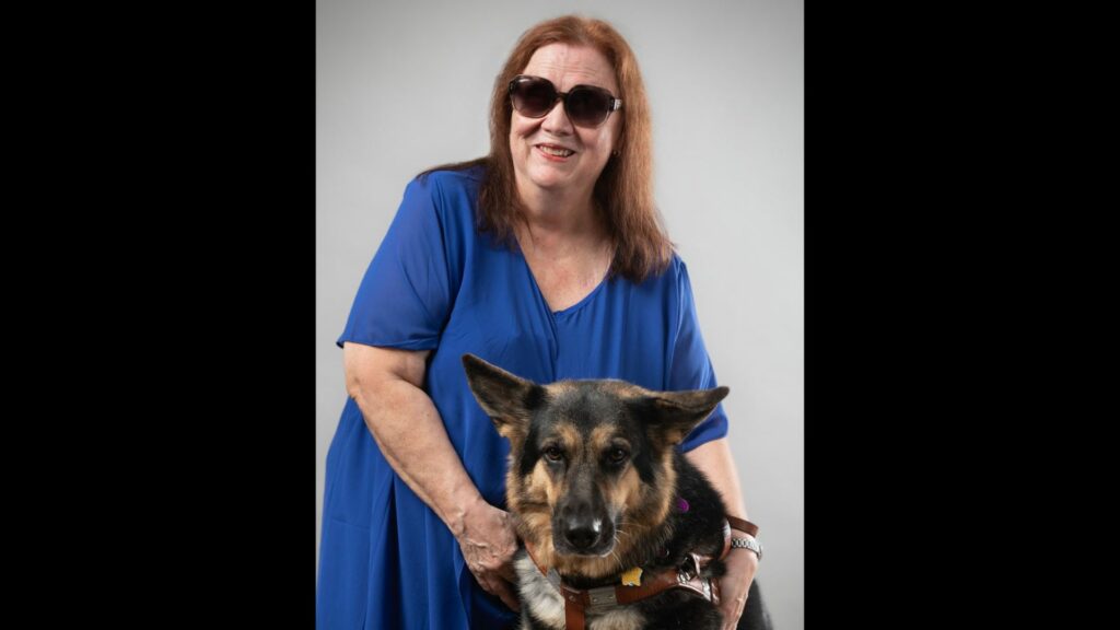 Professional photo of person with arms around a German Shepherd dog guide